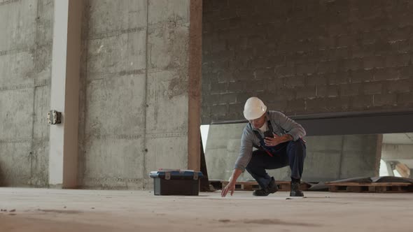 Worker Looking at Papers on Floor