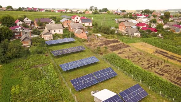 Aerial view of a row of  blue solar panels installed on the ground in residential area.