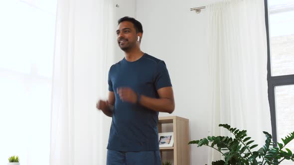 Man with Wireless Earphones Exercising at Home