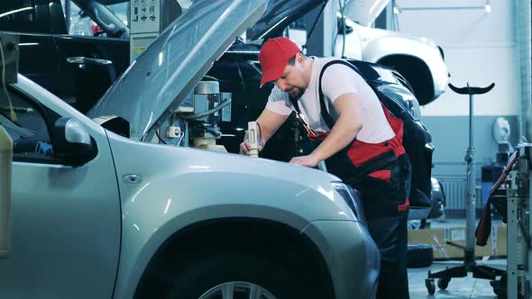 Car Specialist Checks Insides of a Car Using His Flashlight