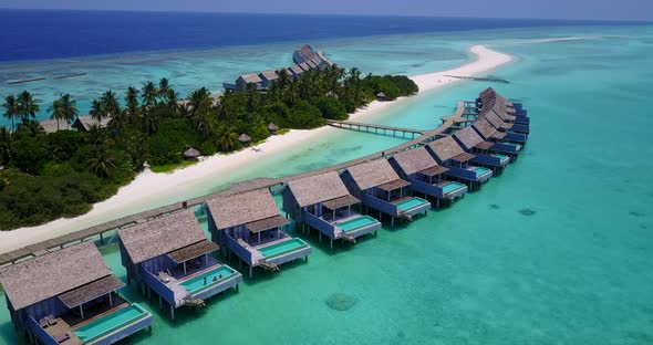 Wide above tourism shot of a sandy white paradise beach and aqua blue water background in hi res 4K