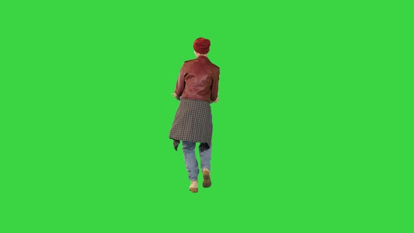 Young Girl in Stylish Urban Clothes Walks Dancing on a Green Screen Chroma Key