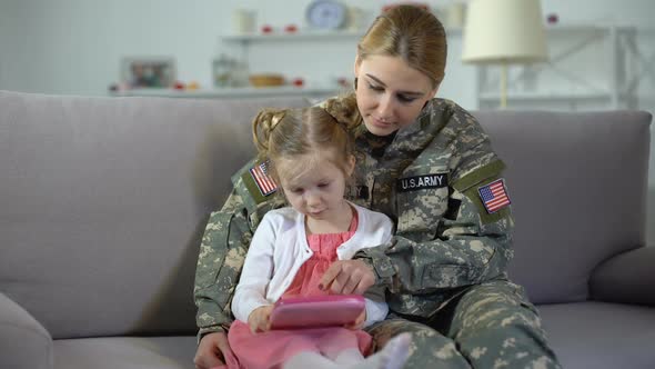 Military Mother Teaching Little Girl Playing on Toy Tablet, Educational Gadget