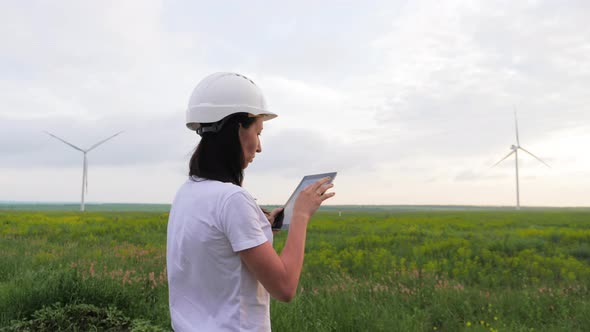 Woman Engineer Working in Wind Turbine Electricity Industrial at Sunset