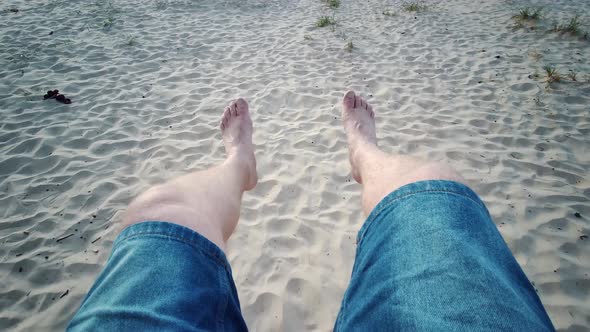 Legs on the Swing, Pov. Man's Feet as He Sits on a Moving Swing at the Beach. First View of a Man on