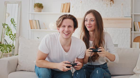 Caucasian Married Couple Friends Young Woman and Millennial Man Sitting at Home Couch Playing Video