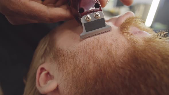 Barber Shaping Beard of Client with Trimmer