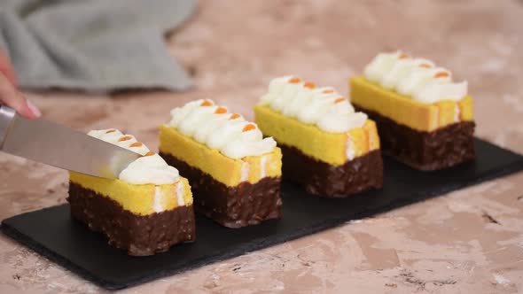 Woman Cut Mini Small Cake with Chocolate Glaze and Whipping Cream