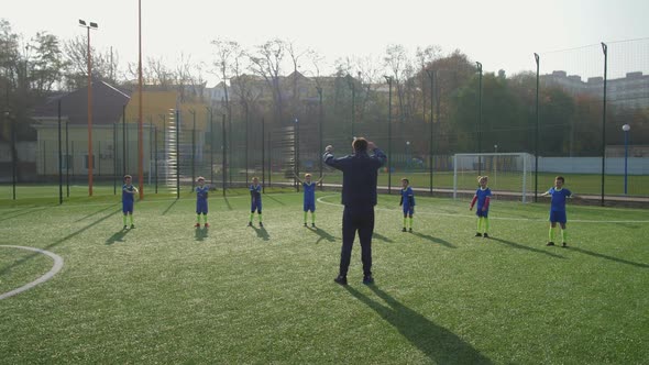 Children with Coach During Warm Up of Soccer Team