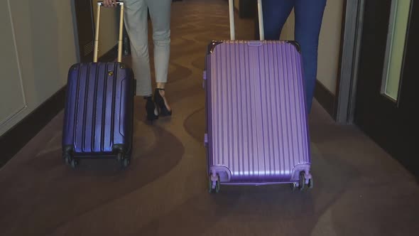 Multiethnic Couple Walks with a Suitcases Down the Hotel Corridor