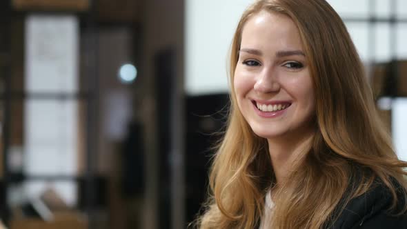 Portrait of Smiling Beautiful Girl Sitting Indoor