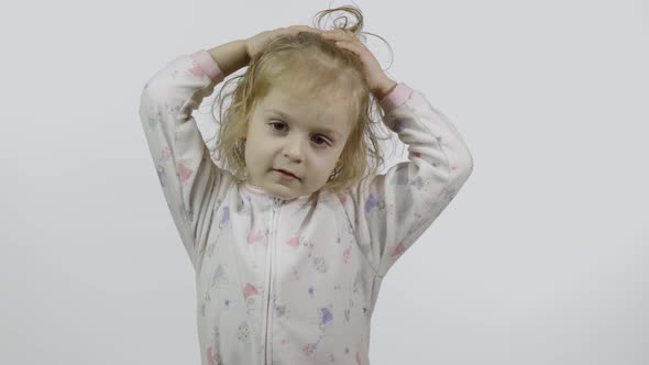 Little Baby Girl in Pajama Is Fooling Around and Make Faces