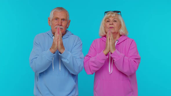 Senior Grandfather Grandmother Praying to God Begging Apology or Help on Blue Studio Background