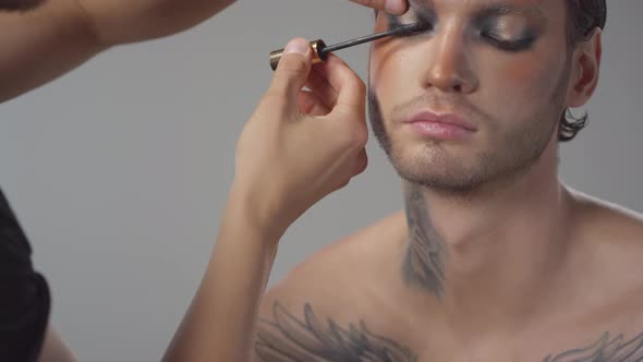 Male MUA Putting Mascara on Man