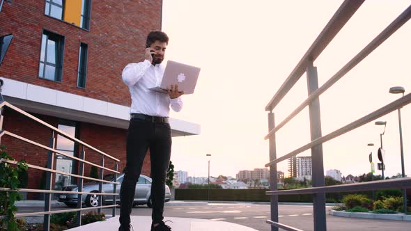 Young Caucasian Businessman Talking To a Customer on His Smartphone