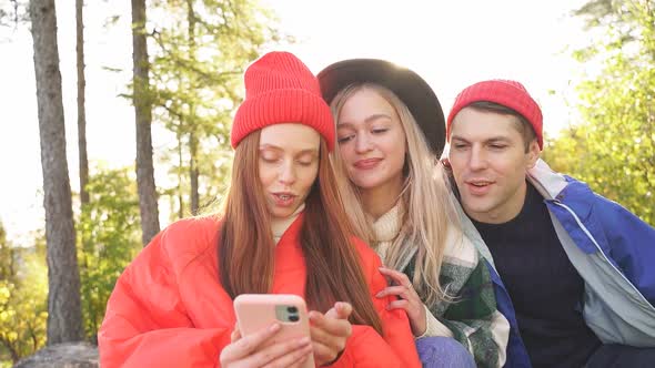 Caucasian Friends Rest on Mountains Use Smartphone