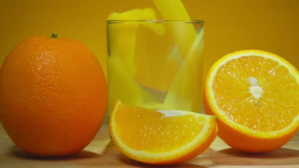 Fresh Sweet Orange Juice is Poured in a Glass Next to Ripe Oranges