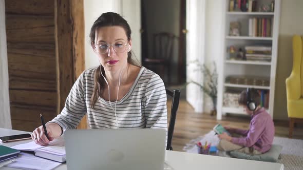 Young European Woman is Having Video Call with Using Laptop at Table in House Interior Spbd