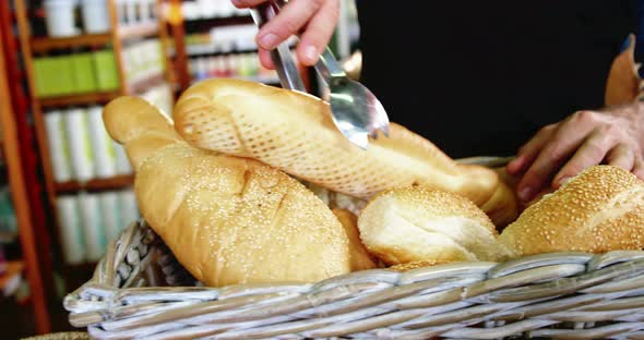 Male staff arranging a loaf of bread in wicker basket