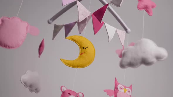 Baby Mobile with Pink Handstitched Animal and Bird Toys with Yellow Moon on White Wall Background