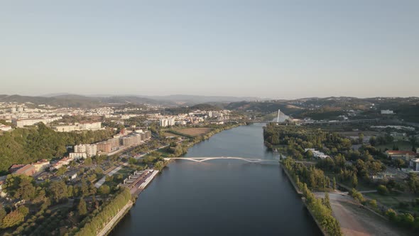 Fly over Mondego river, Coimbra riverside aerial view, Portugal