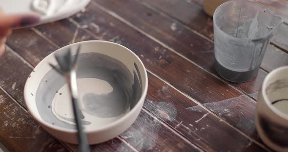 Pottery Artist Decorating Ceramic Pot By Brush at Pottery Workshop