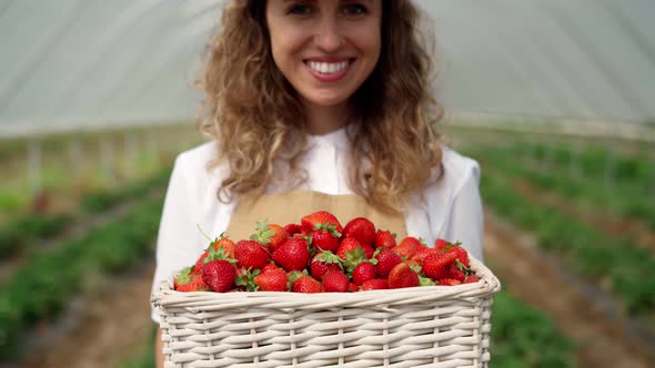 Beautiful Smiling Woman Holding Ripe and Fresh Strawberry