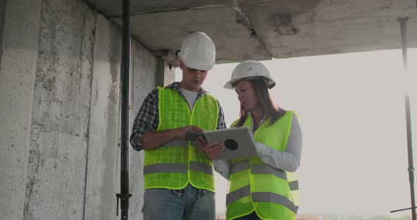 Engineers Designers Stand on the Roof of the Building Under Construction and Discuss the Plan and