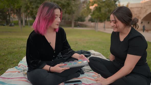 Friends in the Park Having a Conversation About Makeup Palette Colors