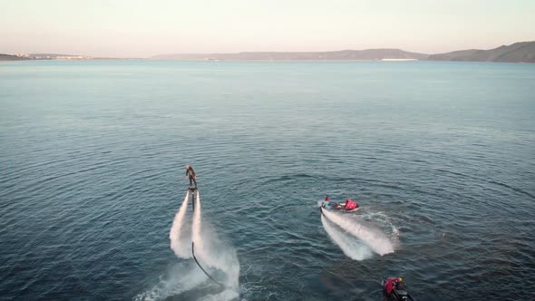 Sportive People Flying Over Water with Jet Packs