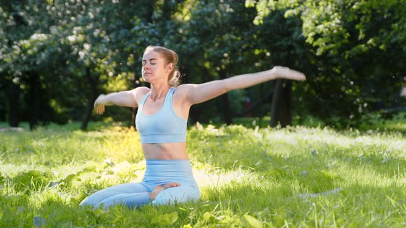 Sportive lady athlete in tracksuit practices yoga exercise