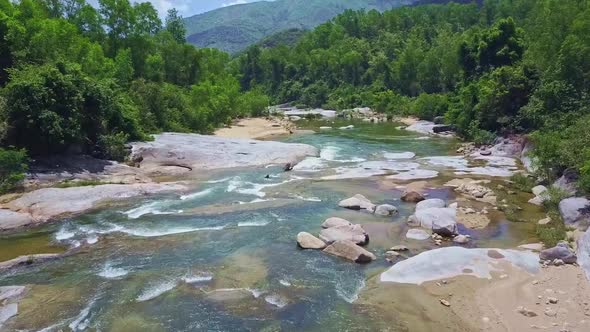 Drone Flies Closely To Mountain River with Rocky Banks