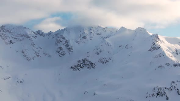 Old Mountains with Snowy Peaks Under Blue Sky with Clouds