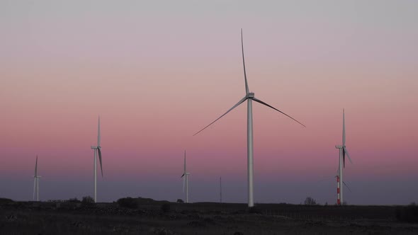 Wind turbines rotating at sundown spinning at dusk