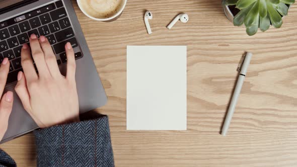 Mockup a Blank Paper Lies on the Desktop of a Young Woman