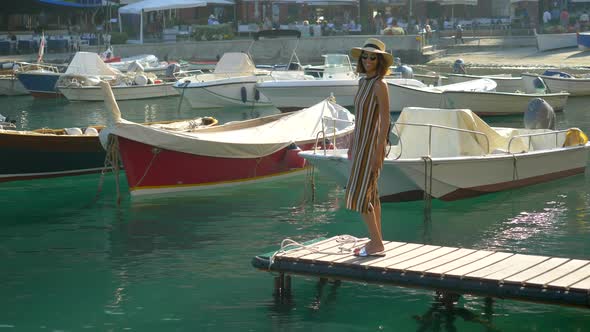 A woman on a boat dock in Portofino, Italy, a luxury resort town in Europe