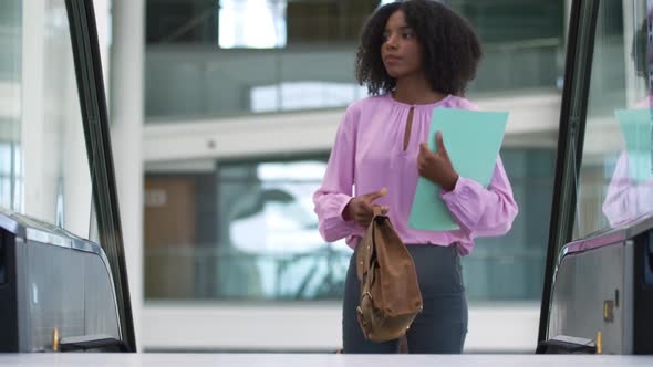 Young businesswoman on an escalator in a modern building