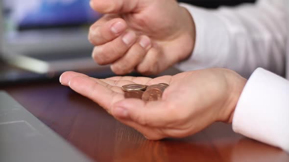 Businessman Counting Coins in the Office