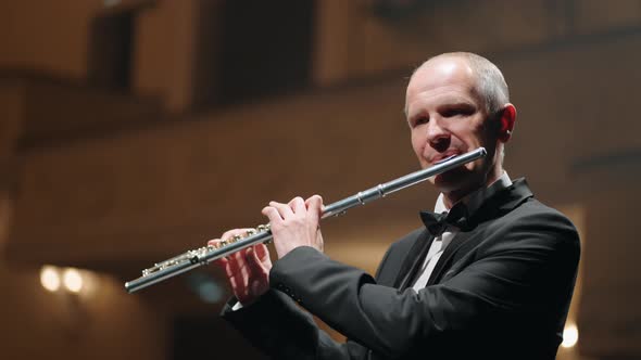 Portrait of Aged Man with Flute on Scene of Old Music Hall or Opera House Talented Musician is