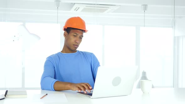 Afro-American Engineer Working On Laptop in Office