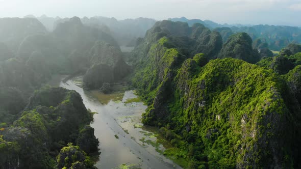 Aerial: North Vietnam karst landscape at sunset, drone view of Ninh Binh region, tourist destination