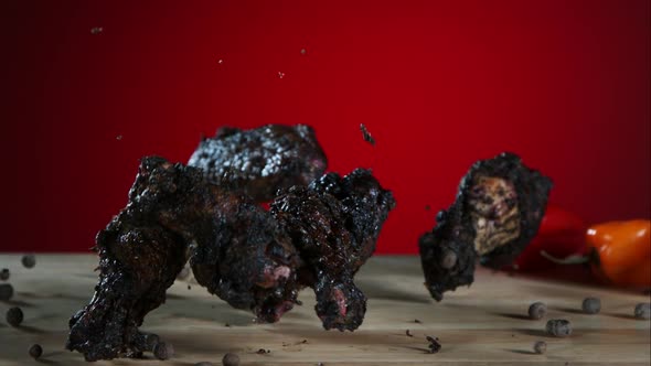 Smoked chicken wings falling and bouncing in ultra slow motion 