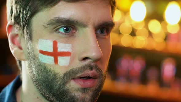 Male Football Fan With English Flag on Cheek Upset About Favorite Team Loss