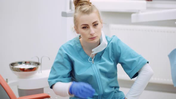 Medium Shot of Exhausted Dentist Sitting at Chair