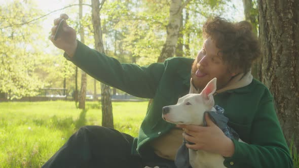 Man Taking Selfie with Dog in Park