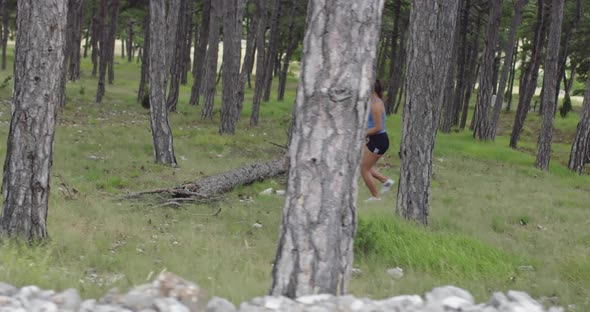 Female Athlete Running Through the Forest