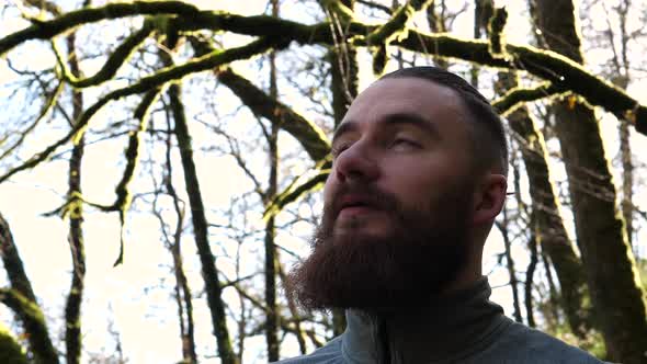 HEADSHOT of young bearded man amidst beautiful nature