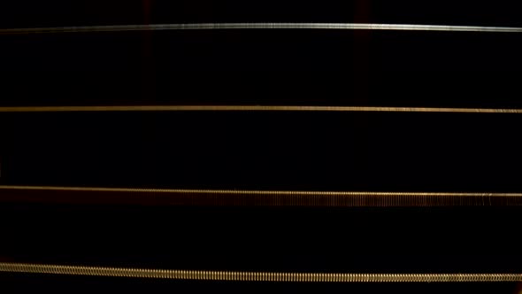 Macro Shot of Acoustic Guitar Strings on Black Background