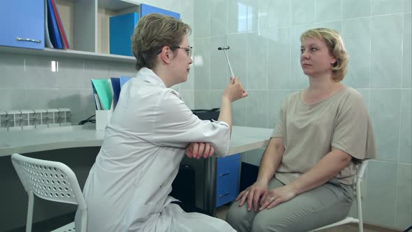 Female Neurologist Performing Neurological Tests on A Female Patient in An Office