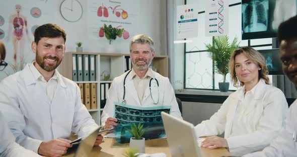 Male and Female Doctors which Posing on Camera Sitting Around Workplace in Clinic office